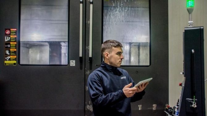 Operario delante de una maquina cnc de mecanizado utilizando ERIS