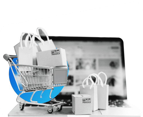 Imagen de un carro con unos regalos en frente de un ordenador portatil.
